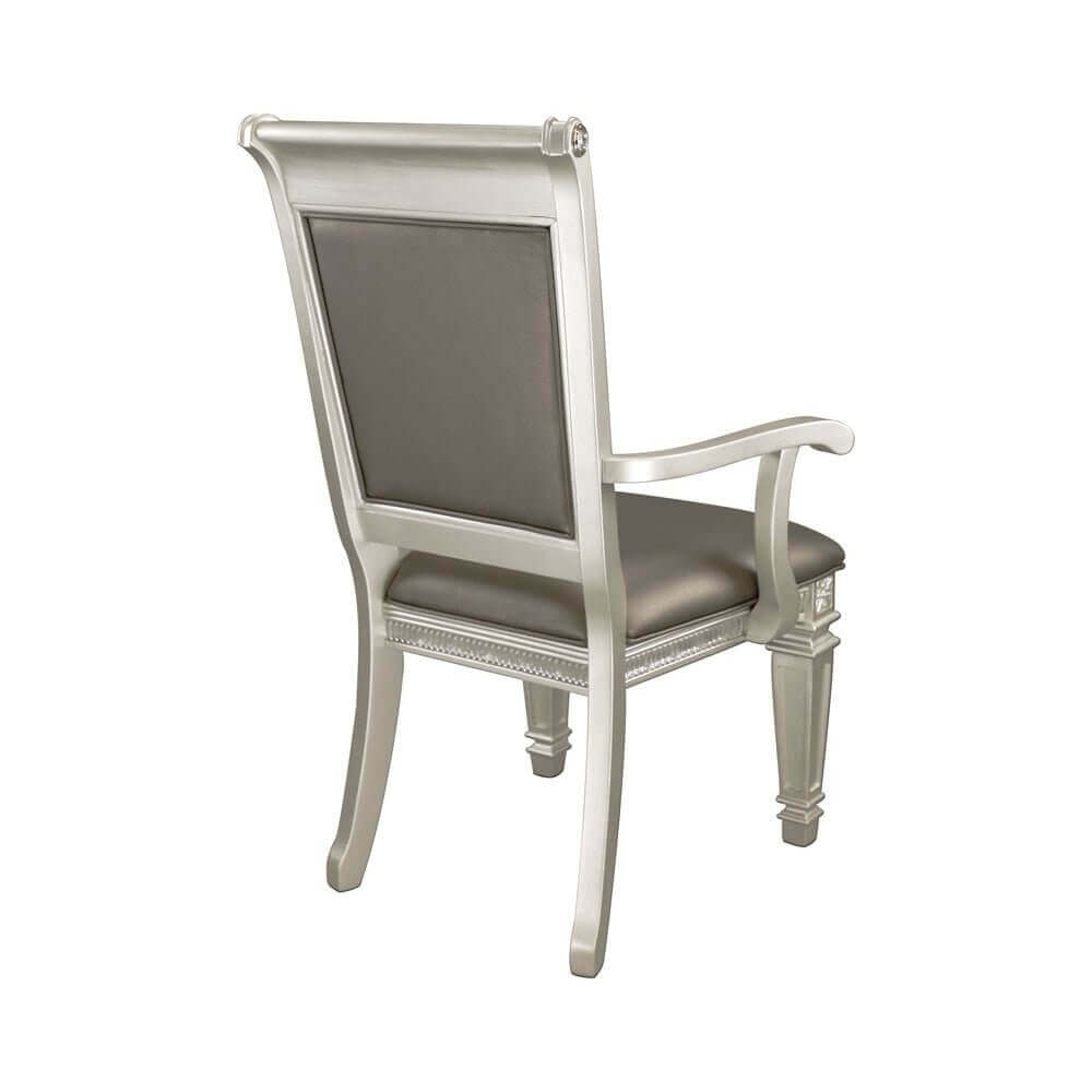 Elegant silver chair with cushioned seat and backrest, featuring detailed woodwork on the legs and armrests.