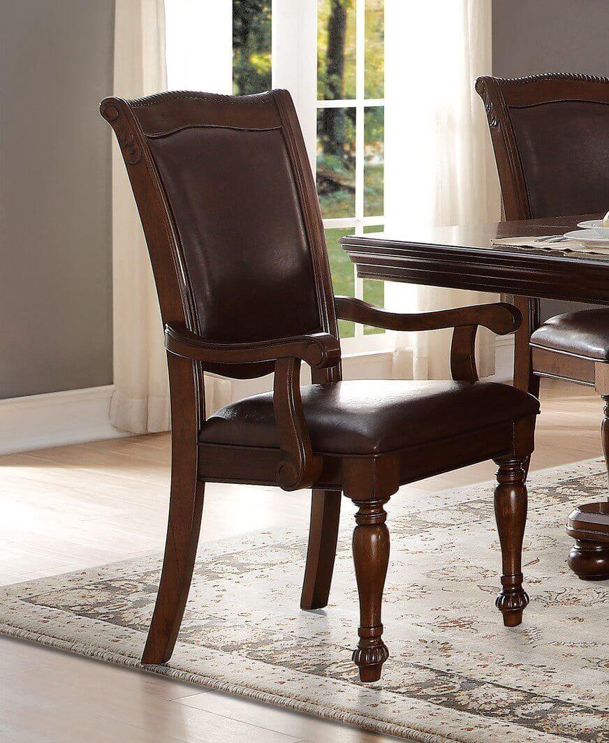 Traditional style armchair with brown cherry finish and upholstered seat placed next to a dining table in a well-lit room.