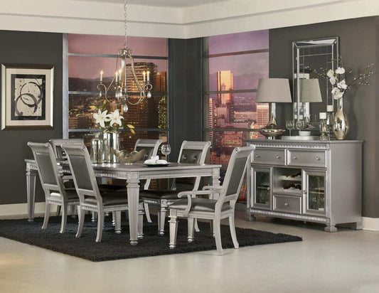 Modern glamorous dining room featuring a silver finish 7pc dining set with a table, two armchairs, four crystal-tufted side chairs, and cityscape backdrop.