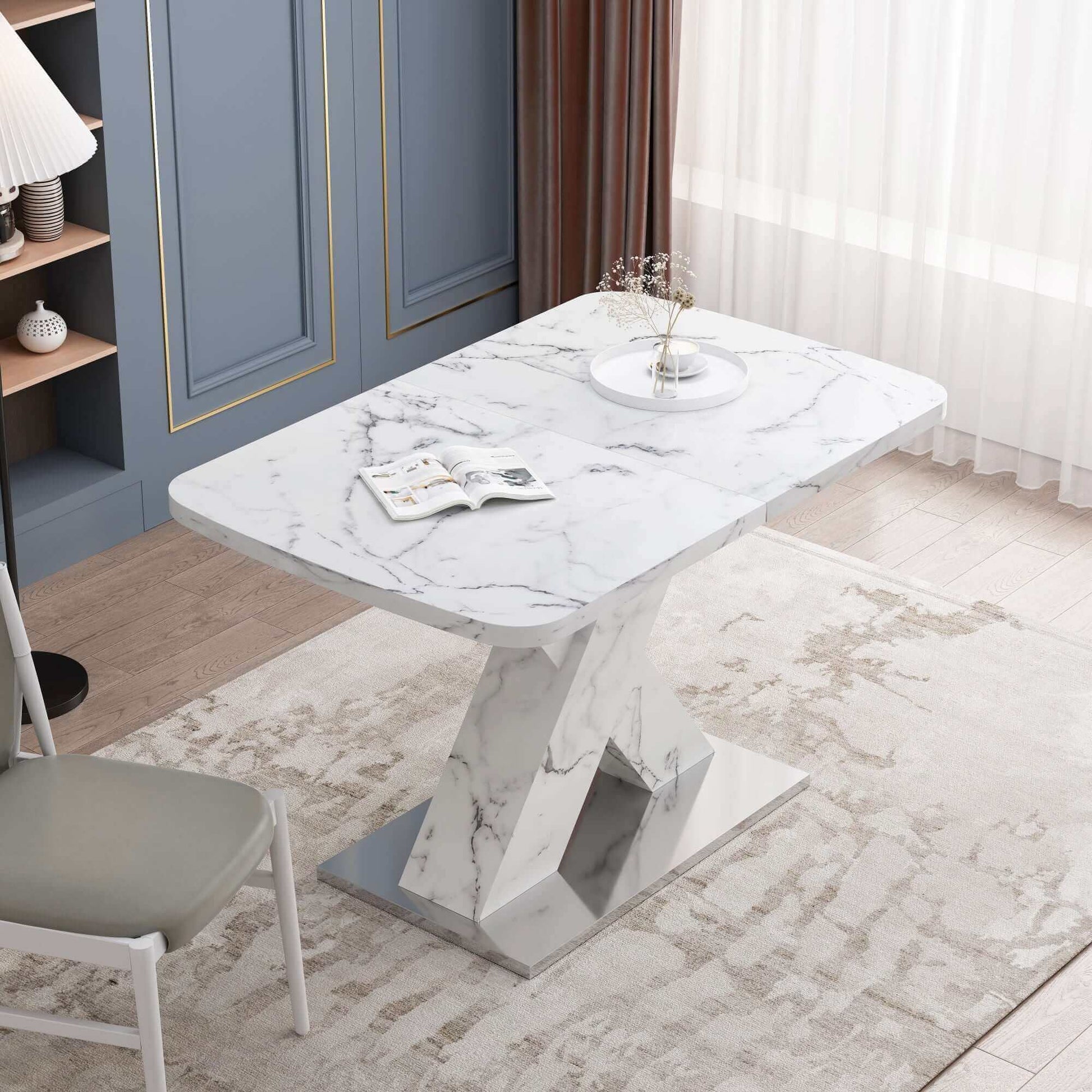 Modern stretchable white marble dining table with metal base, set in a stylish dining room with elegant decor and natural lighting.