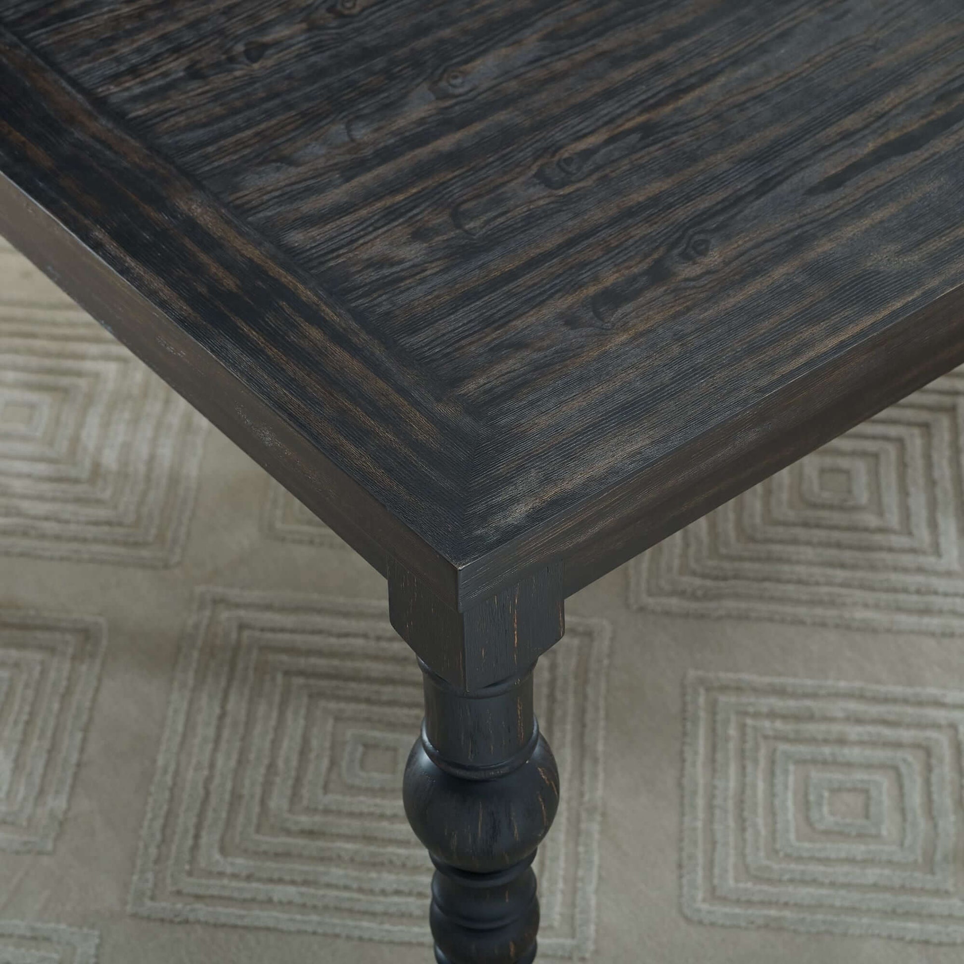Close-up of Leviton Urban Style dark wash wood dining table showcasing elegant texture and design.