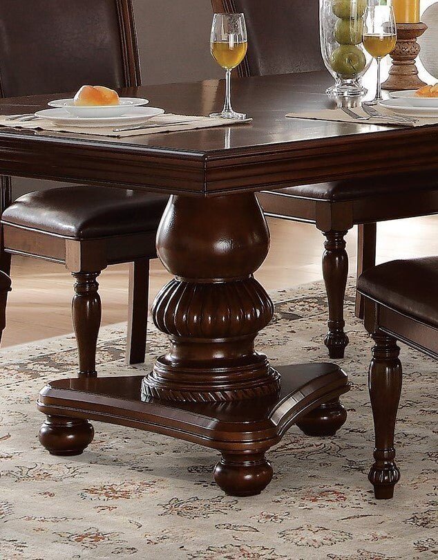 Traditional style dining table with brown cherry finish and upholstered seats, featuring detailed wood pedestal, set for dining