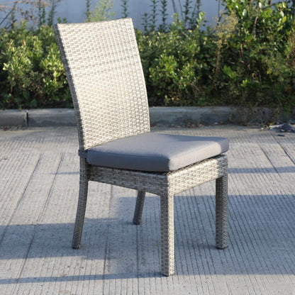 Single chair from Balcones 9-Piece Outdoor Dining Table Set in gray wicker with dark gray cushion, set against outdoor foliage.